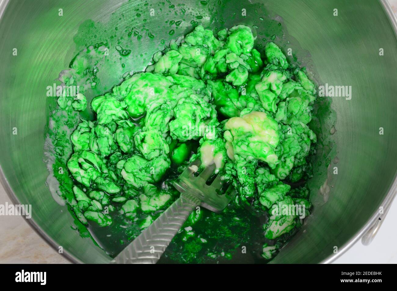 Teig für grüne St. Patrick`s Day Cookies durch Mischen Butter Ei und grüne Lebensmittel Färbung Stockfoto